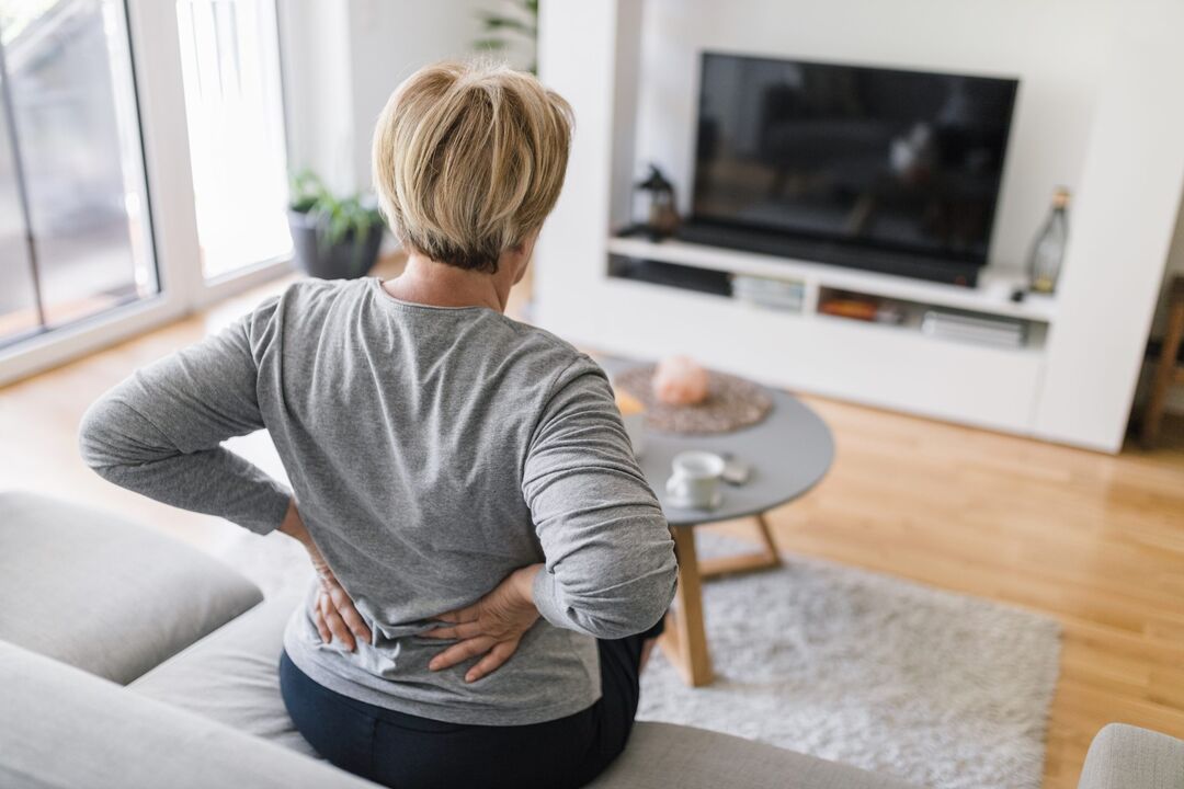 Một phụ nữ lo lắng về chứng đau lưng ở vùng thắt lưng